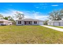 Single story home with gray exterior, well-manicured lawn, concrete driveway, and a one-car garage at 4030 Se 134Th St, Belleview, FL 34420