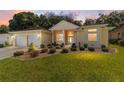 Beautiful single-story home with manicured front yard, mature trees, and welcoming facade at sunset at 11017 Sw 71St Cir, Ocala, FL 34476