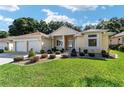 Charming single-story home boasts a meticulously landscaped yard with lush lawn and colorful shrubs at 11017 Sw 71St Cir, Ocala, FL 34476