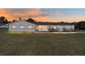 Beautiful exterior view of a single story home with a large lawn at sunset at 4011 Se 47Th Pl, Ocala, FL 34480