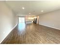 Spacious living room featuring wood floors that flow into the kitchen and a sliding glass door that leads to the backyard at 10107 Sw 41St Ave, Ocala, FL 34473