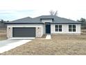 Single-story home featuring a gray roof, two-car garage, and stone veneer accents at 10131 Sw 41St Ave, Ocala, FL 34476