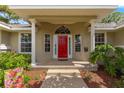 Welcoming front entrance with a bright red door, decorative columns, and manicured landscaping at 2215 Se 24Th Ave, Ocala, FL 34471