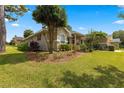 Attractive single-story home with a well-kept lawn, beautiful landscaping, and red accents on the shutters at 2215 Se 24Th Ave, Ocala, FL 34471
