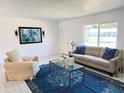 Living room showcasing a comfortable couch, stylish rug and large window at 11 Cedar Trace Crse, Ocala, FL 34472