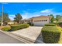 Inviting single-story home with a spacious driveway and a lush green lawn with decorative shrubbery at 9882 Sw 89Th Lane Rd, Ocala, FL 34481