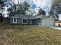A beautiful single-story home featuring gray paint, a new roof and well-maintained landscaping at 3 Dogwood Trl, Ocala, FL 34472