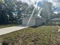 Rear view of a one story home that features an attached 2 car garage and well manicured lawn at 3 Dogwood Trl, Ocala, FL 34472