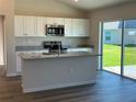 New kitchen featuring an island with granite countertop and modern appliances at 3490 Sw 155 Ln, Ocala, FL 34473