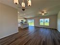 Bright living room featuring wood floors, a ceiling fan, and an adjacent modern kitchen area at 3490 Sw 155 Ln, Ocala, FL 34473