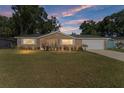 Tan single-story house with a large yard and attached garage at dusk at 8389 Sw 108Th Pl, Ocala, FL 34481