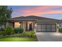 Beautiful single-story home featuring manicured lawn, colorful sunset and a two car garage at 7709 Sw 86Th Ct, Ocala, FL 34481
