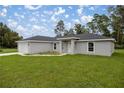 Gray house with a covered entryway and landscaped lawn at 14573 Sw 25Th Ter, Ocala, FL 34473