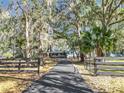 Long driveway leading to a house nestled amongst the trees at 7131 Sw 19Th Avenue Road Rd, Ocala, FL 34476