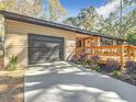 Ranch house with a dark gray garage door and wood deck at 7131 Sw 19Th Avenue Road Rd, Ocala, FL 34476