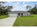 Inviting single-story home with a well-manicured lawn, a freshly painted exterior, and an attached garage at 7336 Sw 131St Ln, Ocala, FL 34473