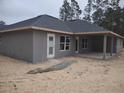 New home showcasing rear elevation with covered patio and sandy lot at 4378 Sw 113Th Pl, Ocala, FL 34476