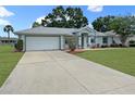 Charming single-story home with a well-maintained lawn and a spacious driveway leading to a two-car garage at 4937 Nw 30Th Pl, Ocala, FL 34482