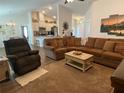 Inviting living room featuring a comfortable sectional sofa and an open floor plan to the kitchen at 9029 Se 47Th Court Rd, Ocala, FL 34480