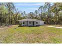 Inviting single-story home featuring a well-maintained lawn and a charming front entryway in a wooded location at 11404 Sw 131St Ter, Dunnellon, FL 34432