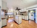 Spacious kitchen with a center island, stainless steel appliances, and wood-look flooring at 34828 1St Ave, Leesburg, FL 34788