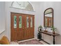 Elegant foyer featuring double doors with decorative glass and a stylish console table with mirror at 4893 Sw 4Th Cir, Ocala, FL 34471
