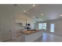 An open kitchen features modern appliances, white cabinets, granite counters and an island with a sink at 5892 Sw 82Nd Ln, Ocala, FL 34476