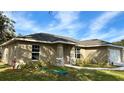 One-story house with tan exterior, landscaping, and a walkway at 9285 Se Highway 42, Summerfield, FL 34491
