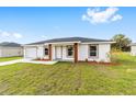 Inviting single-Gathering home featuring a lush green lawn and attractive landscaping with wood column accents at 14363 Sw 27 St, Ocala, FL 34481