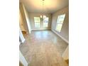 Bright dining room with tile floors, modern chandelier, and large windows offering ample natural light at 3106 Ne 46Th Ave, Ocala, FL 34470