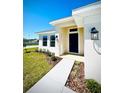Inviting front entrance featuring a well-lit walkway, manicured landscaping, and a stylish black front door at 3106 Ne 46Th Ave, Ocala, FL 34470
