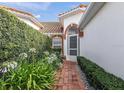 Inviting front entrance with a brick pathway, arched entryway, and lush landscaping at 5162 Harbour Dr, Oxford, FL 34484