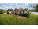 This home features a manicured lawn with lush shrubbery and garden at 10291 Se 42Nd Ter, Belleview, FL 34420
