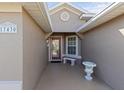 Inviting front porch featuring a decorative urn and a comfortable bench near the patterned glass front door at 17430 Se 110Th Ter, Summerfield, FL 34491