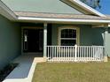 View of the front porch and front door of a quaint single Gathering home at 8949 Se 159Th Ln, Summerfield, FL 34491