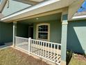 Covered front porch featuring classic white railings and complementary trim at 8949 Se 159Th Ln, Summerfield, FL 34491