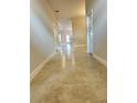 A long hallway with beautiful tiles connecting the front door to the rest of this open floor plan home at 3127 Ne 45Th Ave, Ocala, FL 34470