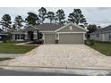 Beautiful single-story home with brick driveway, a two-car garage, and inviting front lawn at 7143 Sw 179Th Court Rd, Dunnellon, FL 34432