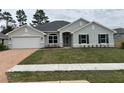 Charming one-story home with lush green lawn and a two-car garage and stone pathway at 7173 Sw 179Th Court Rd, Dunnellon, FL 34432