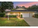 Beautiful single-story home at sunset featuring lush landscaping and a two-car garage at 9068 Sw 82Nd Ter # A, Ocala, FL 34481