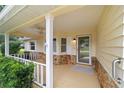 Inviting covered porch with stone accents, a ceiling fan, and a glass front door at 9068 Sw 82Nd Ter # A, Ocala, FL 34481