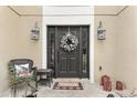 Close-up of a welcoming front door decorated with a holiday wreath and stylish lanterns at 4535 Se 32Nd Pl, Ocala, FL 34480