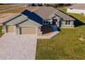 Beautiful one-story home with a three-car garage, paver driveway, and a well-maintained lawn at 17887 Sw 72Nd Street Rd, Dunnellon, FL 34432