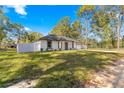 Single story home with a white exterior, gray accents, and a fenced backyard at 14152 Se 43Rd Ter, Summerfield, FL 34491