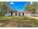 Newly built home features gray door and white exterior at 14152 Se 43Rd Ter, Summerfield, FL 34491