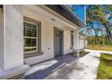 Modern front entrance with gray door and gray framed windows at 14152 Se 43Rd Ter, Summerfield, FL 34491