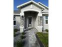 Inviting front entrance with decorative stone pillars and stylish overhead lighting at 17781 Sw 72Nd Street Rd, Dunnellon, FL 34432