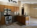 Well-lit kitchen with stainless steel appliances, granite countertops, and hanging pendant lights at 727 Ne 130Th Ter, Silver Springs, FL 34488