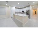 Modern kitchen with white cabinets, stainless steel appliances, and an island at 13850 Se 42Nd Ave, Summerfield, FL 34491