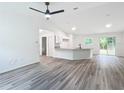 Bright, open-concept living room with modern flooring, a kitchen island, and ample natural light at 24780 Nw Hillsdale Ave, Dunnellon, FL 34431